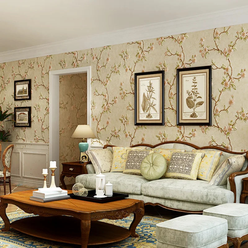 A living room features a sofa and wooden coffee table against a wall covered in floral self-adhesive wallpaper.