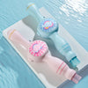 A pink and light blue magic smoke bubble machine with colorful lights resting on a white surface.