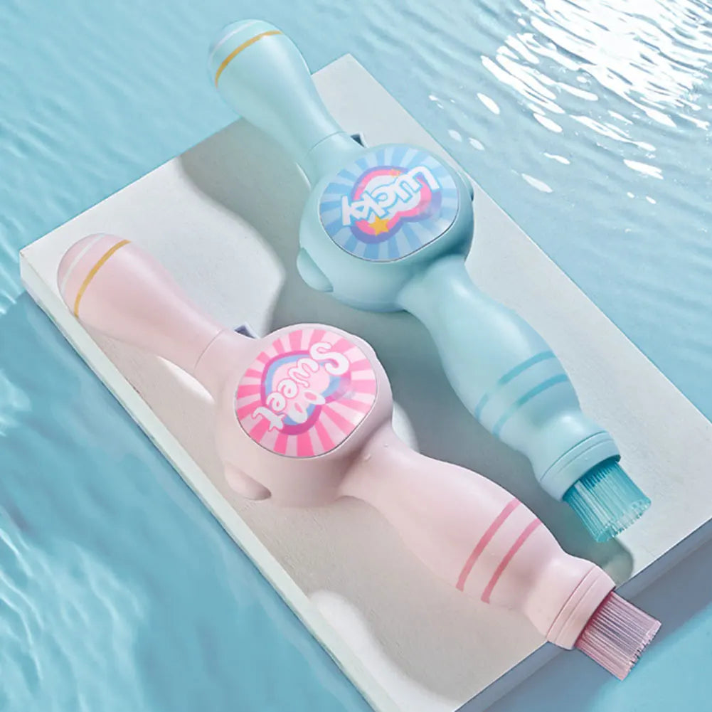 A pink and light blue magic smoke bubble machine with colorful lights resting on a white surface.