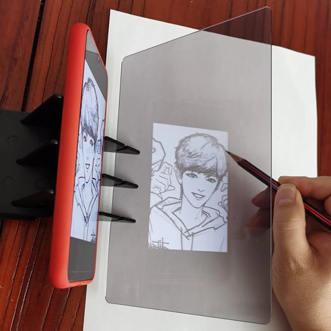 A hand draws on a transparent optical tracing board placed next to a red portable drawing projector.