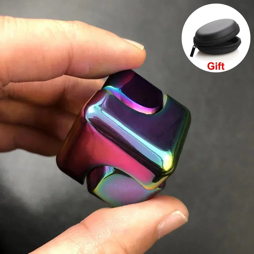 A hand holds a shiny, iridescent alloy metal fidget cube spinner with a black gift pouch.