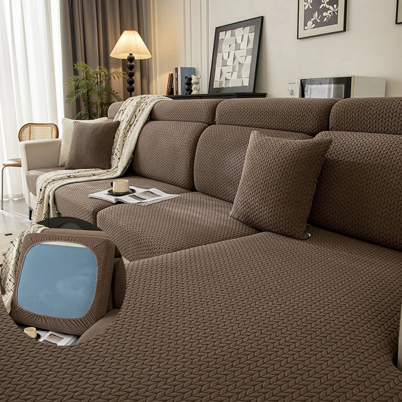 Asiento y funda de cojín de sofá de textura marrón con una manta de color beige claro en una sala de estar moderna.