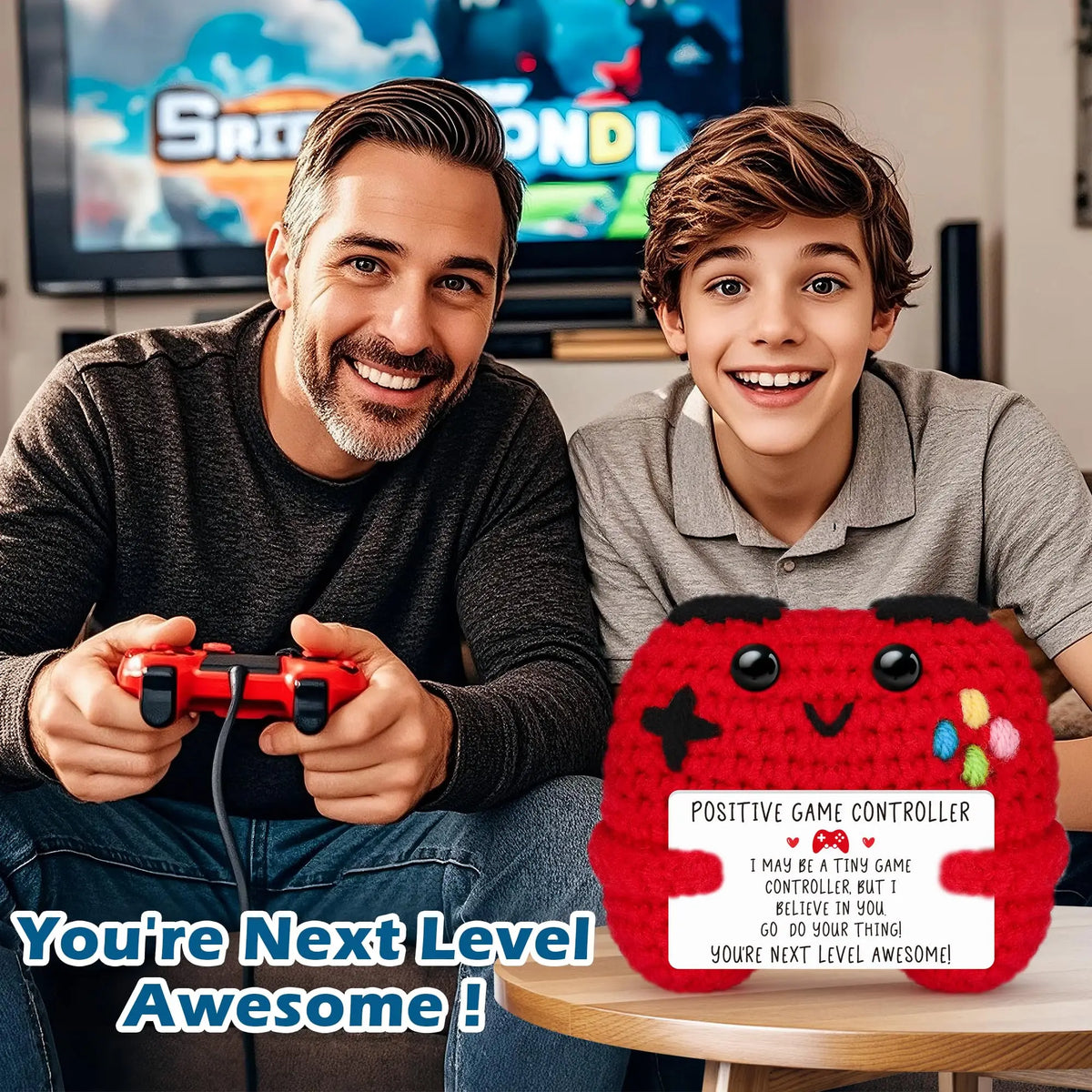 A young boy smiles holding a red handmade crochet game controller decoration.