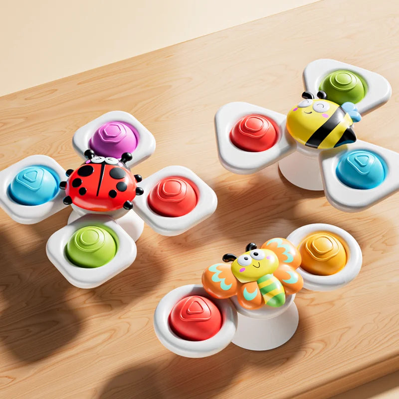 A set of colorful, ocean-themed spinning bath toys with various fruit and animal shapes resting on a wooden surface.