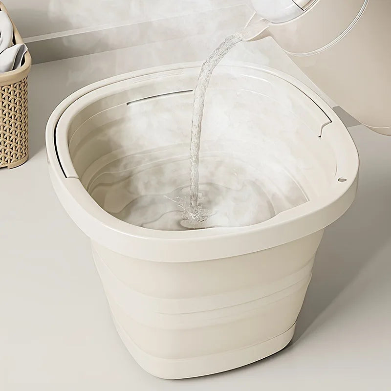 A white collapsible outdoor bucket is being filled with water, creating a mist or steam.