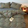 A plaid duvet cover in olive green and beige tones with a grid pattern is displayed on a bed.