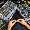 A hand is organizing small metal hardware parts inside a clear plastic storage organizer box.