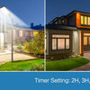 A solar-powered LED security flood light with a motion sensor and remote control is shown illuminating a house at dusk.