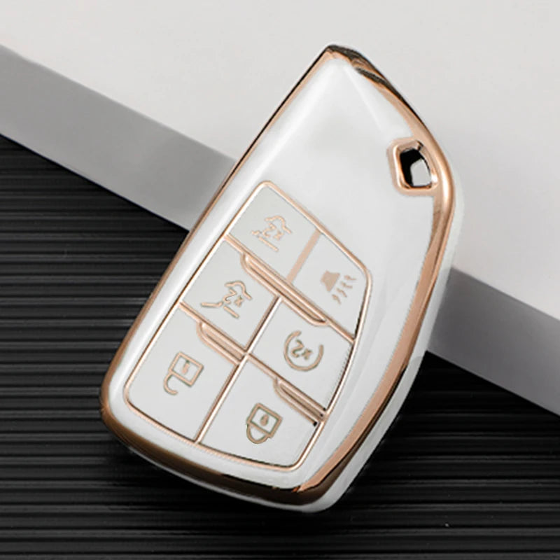 A white and rose gold TPU car key fob cover with various buttons is shown on a dark surface.