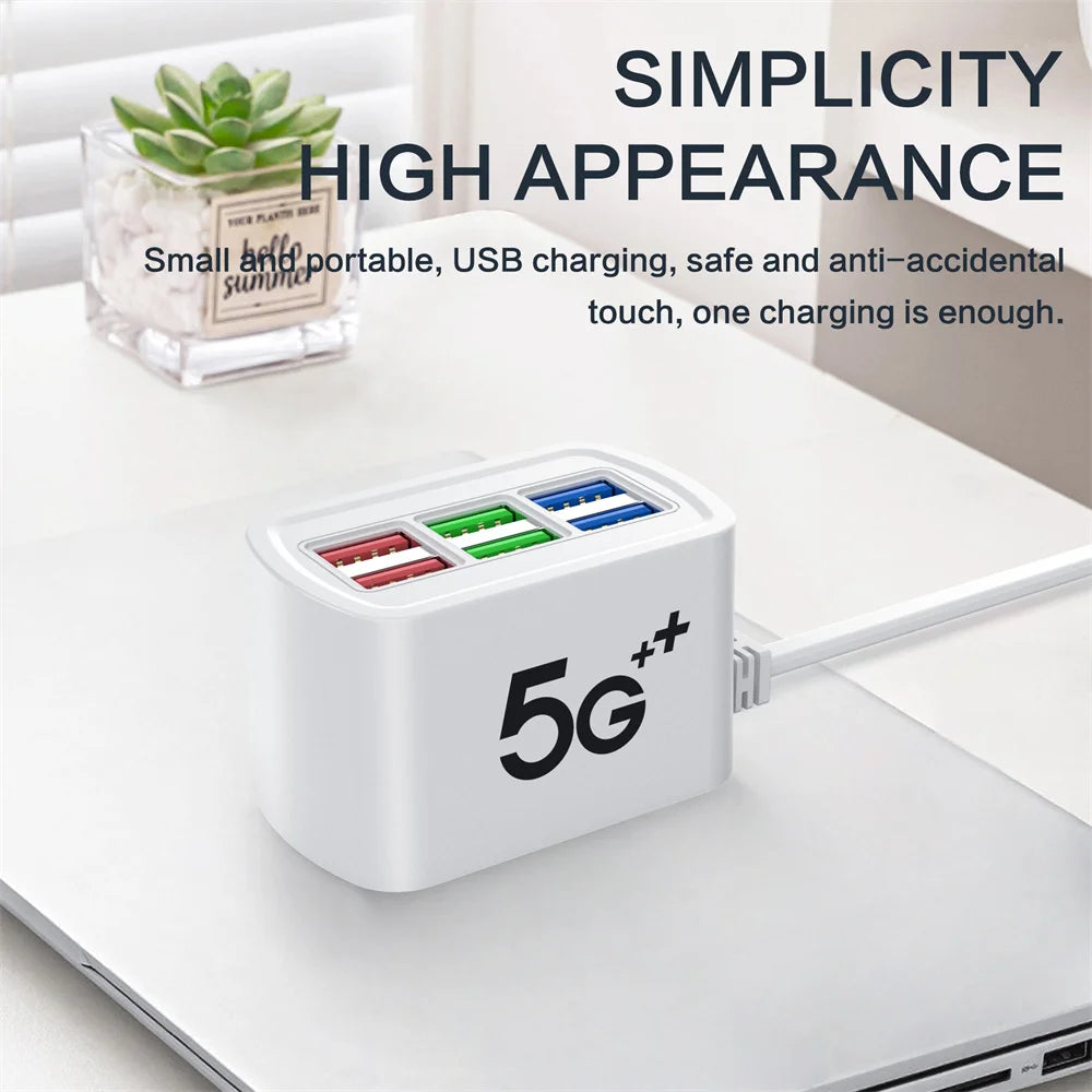 A white desktop USB charging station with multiple ports is shown next to a laptop.