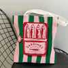 Pink and green striped canvas tote bag featuring a red print of sardines in olive oil.