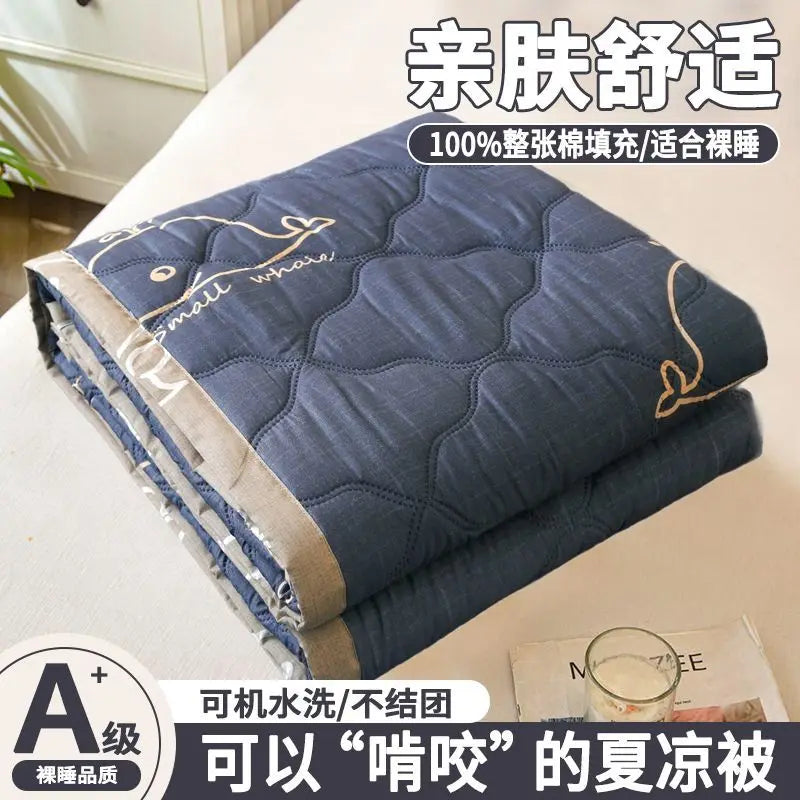 A navy blue quilted blanket folded on a white surface, labeled as an ultra-light breathable summer quilt.