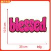 Pink embroidered patch with the word blessed on a gold backing