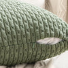 A close-up of a textured, olive green corduroy throw pillow cover with a diamond pattern.