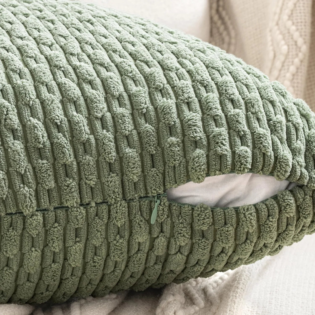 A close-up of a textured, olive green corduroy throw pillow cover with a diamond pattern.