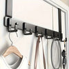 A black over-the-door coat rack with six hooks mounted on a white door, featuring a wooden hanger and a mesh sports bag.