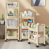 A white mobile multi-tier storage cart with wheels displaying books and stuffed animals.