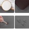 A set of anti-fatigue standing mats featuring a white plate and dark gray textured surfaces.