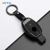 A black slim carbon fiber car key cover with a metal ring and electronic components.
