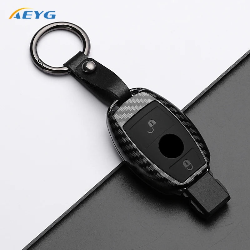 A black slim carbon fiber car key cover with a metal ring and electronic components.