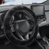 Interior view of a car showing a black fuzzy steering wheel cover and infotainment screen.