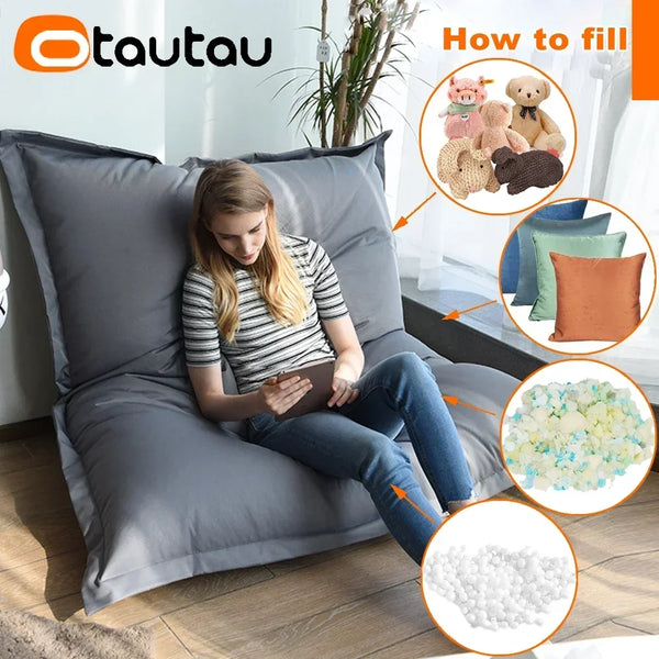 A woman sits on a gray bean bag chair, demonstrating how to fill the waterproof Oxford bean bag cover with foam pellets.