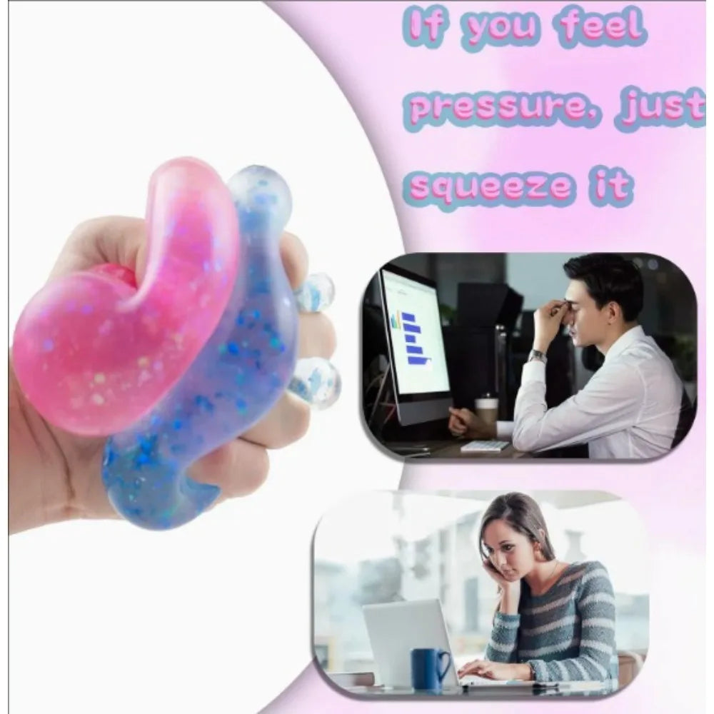 Eine Hand presst einen rosa und blauen Stressball.