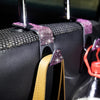 A black car seat storage hook set featuring crystal diamond accents and a tan leather strap.