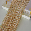 Gold-toned tassel string curtain made of small beads and threads displayed next to a book.