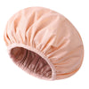 A large, light peach satin-lined waterproof shower cap for hair protection.