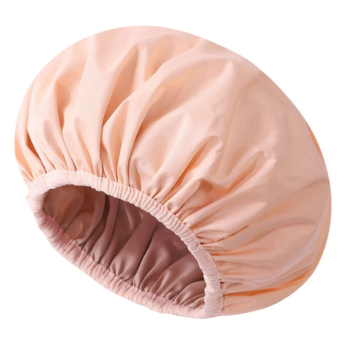 A large, light peach satin-lined waterproof shower cap for hair protection.