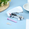 A white portable handheld sewing machine with a pink needle and thread visible on a light blue surface.