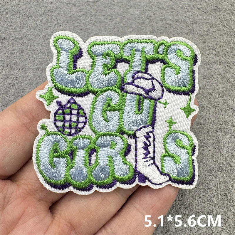 Embroidered patch featuring the text LEGS and GIRS in green and gray thread on a light background