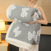 A woman is holding a gray plush jacquard throw blanket with white floral embroidery.