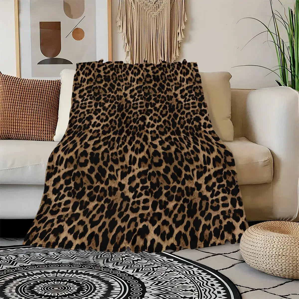 A leopard print flannel throw blanket draped over a light-colored sofa, resting on a patterned rug.