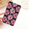 A pink and black floral pattern card holder featuring the name Kate Spade New York
