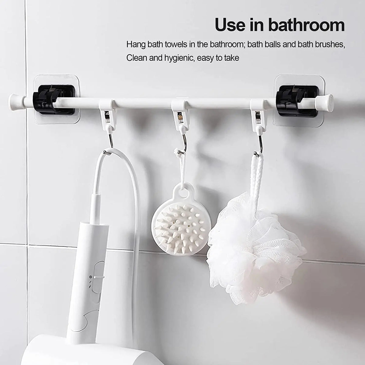 White adhesive curtain rod hooks mounted on a bathroom towel rack for hanging bath towels, balls, and brushes.