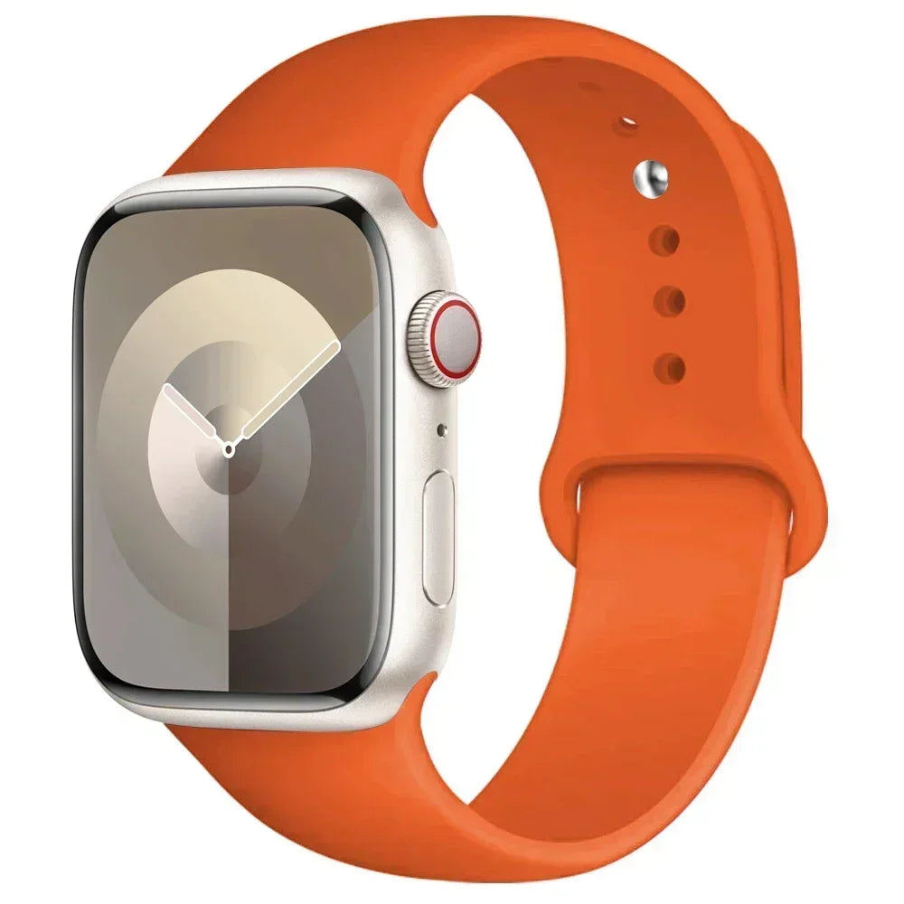 An Apple Watch in a silver case is shown attached to an orange silicone sport band.