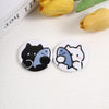 A set of two tinplate pins featuring cute black and gray cat and dog faces on a white background.