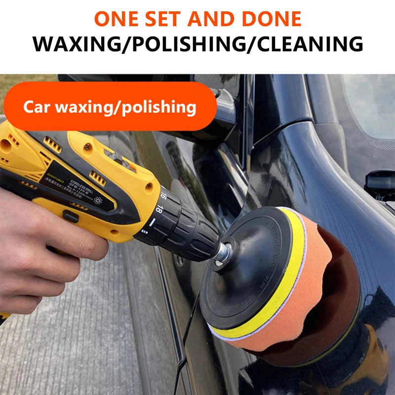 A hand is using a yellow electric polisher with an orange sponge pad on a black car surface for waxing or polishing.