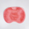 A pink silicone shower scrubber and massage pad for feet and back, showing a textured surface.