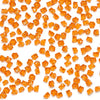 A pile of transparent orange acrylic crushed ice gems used for vase fillers and decor.
