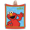 A red Sesame Street character face on a blue background framed by red and striped fabric.