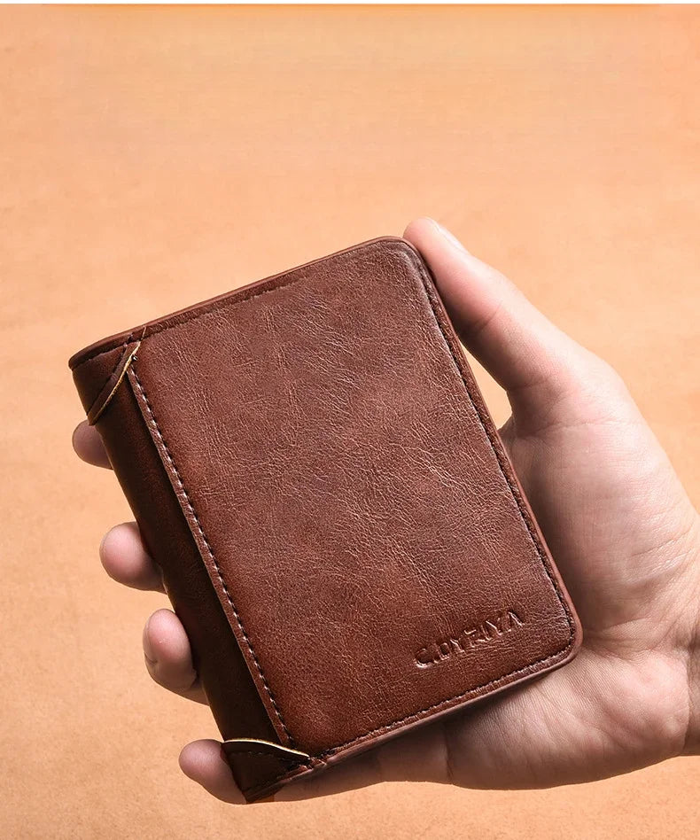 A hand holds a brown slim PU leather card holder wallet for men against a light orange background.