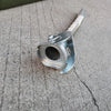 A silver universal jerry can spout with a leak-proof seal, resting on a gray concrete surface.