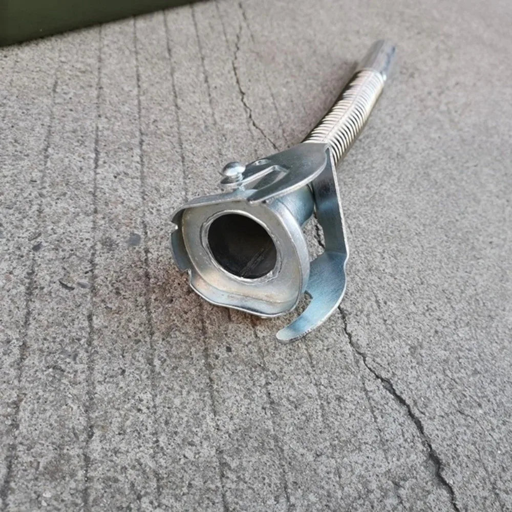 A silver universal jerry can spout with a leak-proof seal, resting on a gray concrete surface.