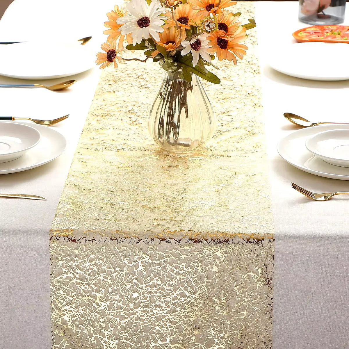 Metallic gold glitter table runner set for weddings and parties with white plates and floral centerpiece