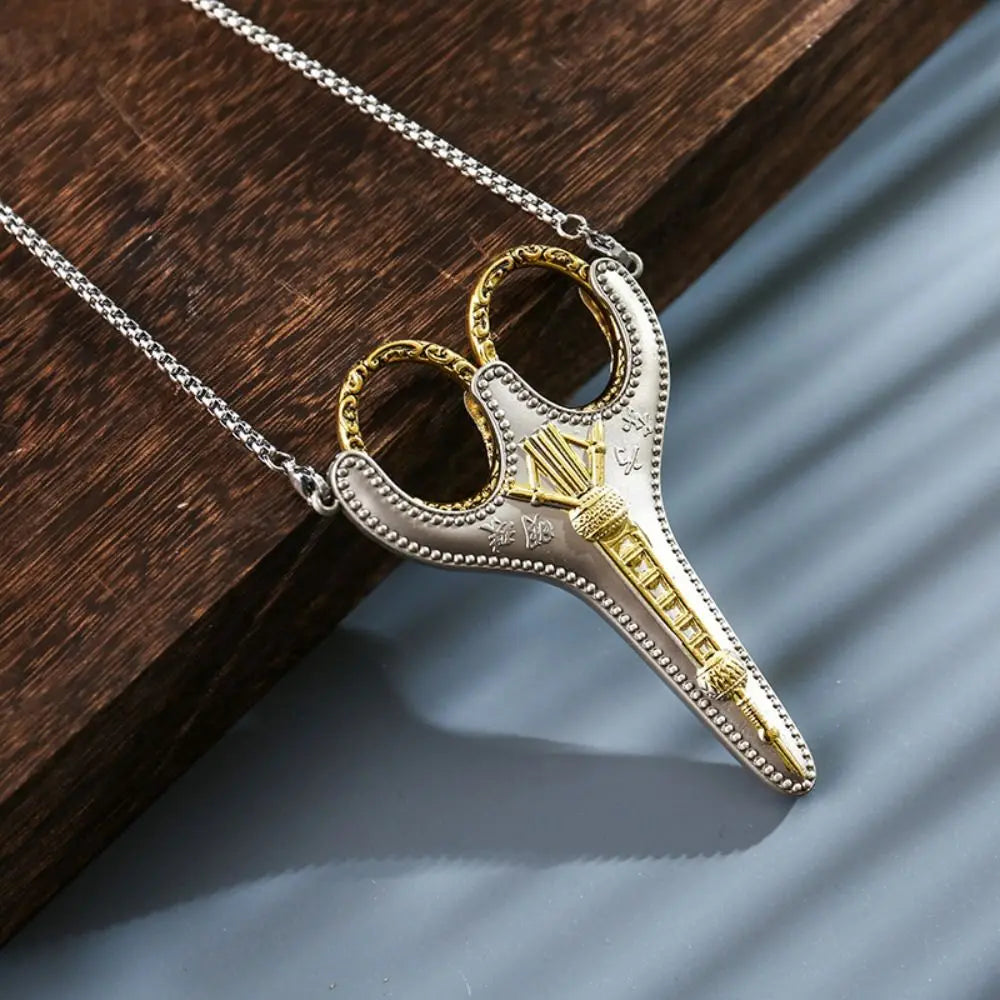 Vintage stainless steel sewing scissors with gold accents hanging from a silver chain