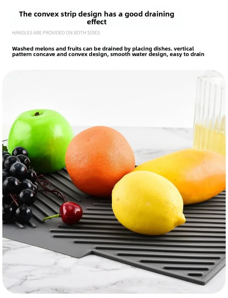 A silicone dish drying mat is shown with various fruits like apples, oranges, and lemons placed on it.