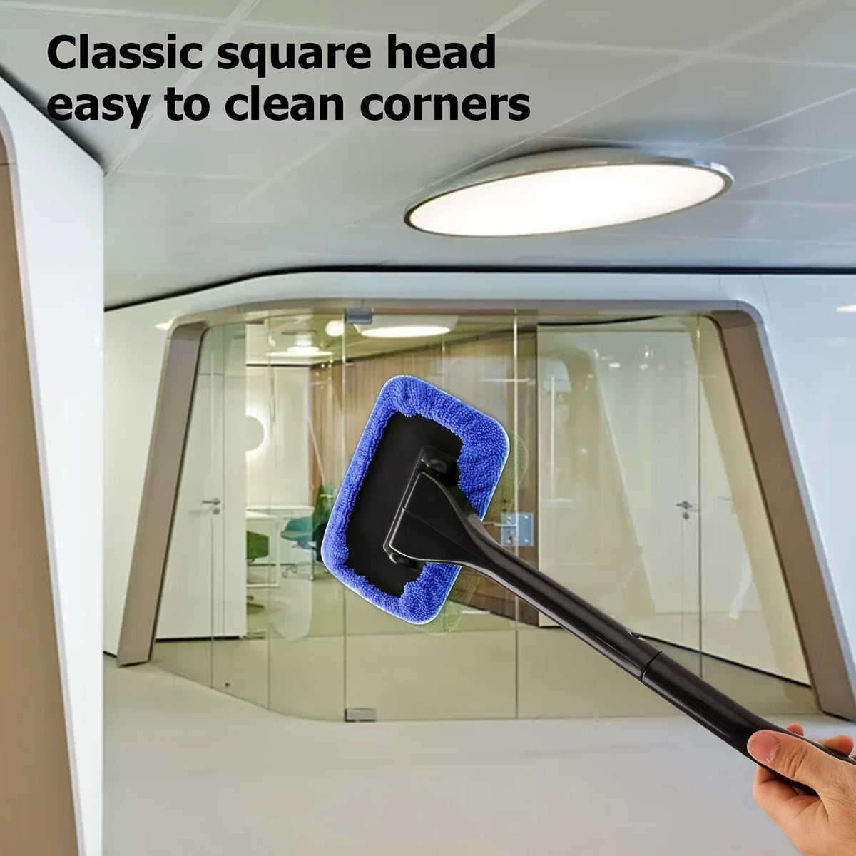 A hand holds a black car windshield cleaning tool with a blue sponge head, demonstrating its use for cleaning corners.